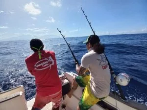 Deux pêcheurs de dos à l’arrière d’un bateau